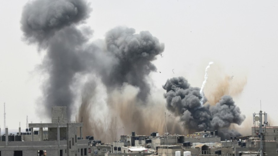 Smoke rises above buildings in Rafah in the southern Gaza Strip following an Israeli strike on May 12, 2023