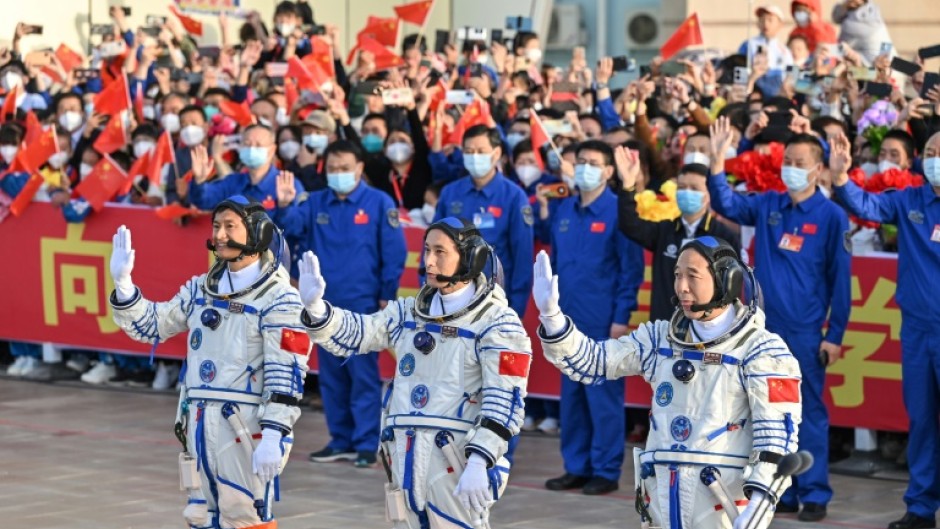 Gui Haichao (L) payload expert, Zhu Yangzhu (C) space flight engineer and commander Jing Haipeng (R) wave during the seeing-off ceremony for the Shenzhou-16 mission to China's space station