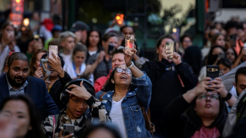 People use their phones to snap pictures of the phenomenon known here as Manhattanhenge

