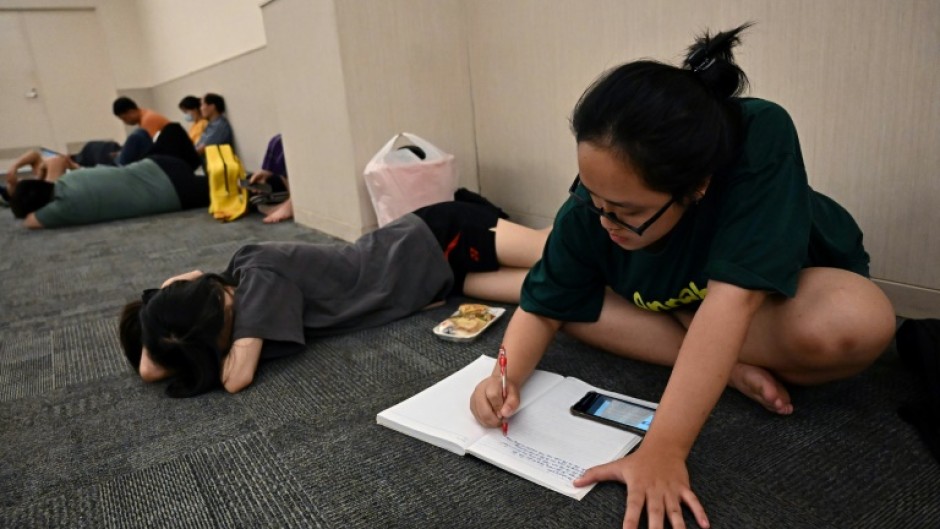Student Nguyen Minh Thu works on an assignment in a room in a mall set aside for people seeking to escape from high outdoor temperatures