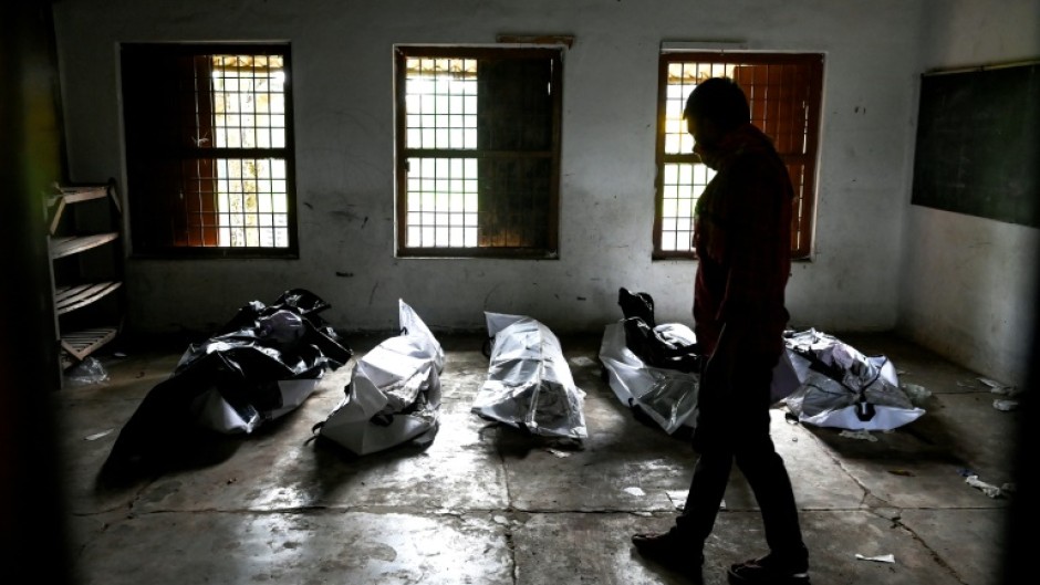 Bodies are laid out at a high school used as temporary mortuary to identify the dead recovered from the carriage wreckage