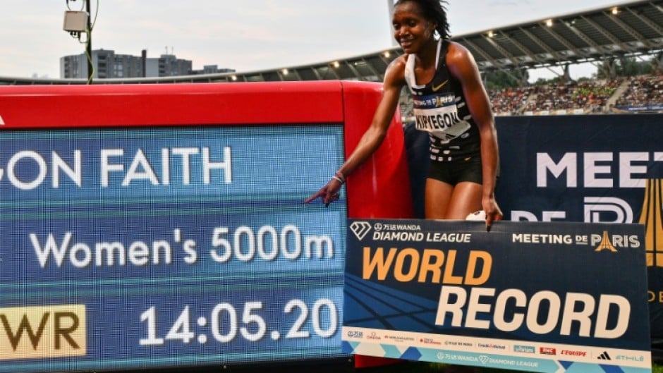Kenya's Faith Kipyegon poses with her time after breaking the world record in the women's 5,000m