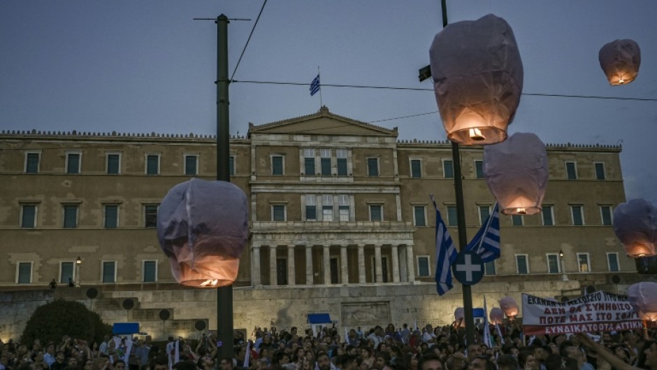 Protesters release hot air balloons in front of the Greek parliament as a tribute to the victims of the disaster