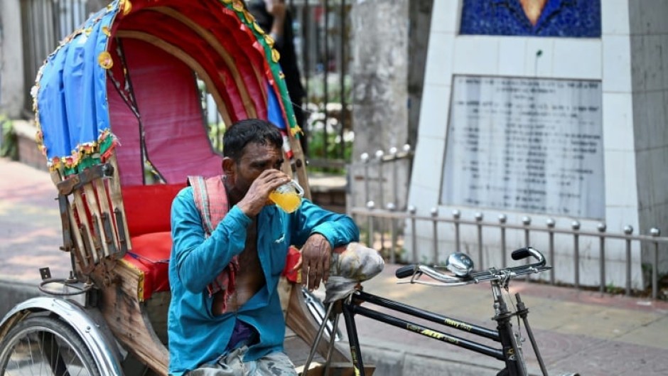 A rickshaw puller quenches his thirst with a juice during a heatwave in Dhaka, Bangladesh on June 6, 2023