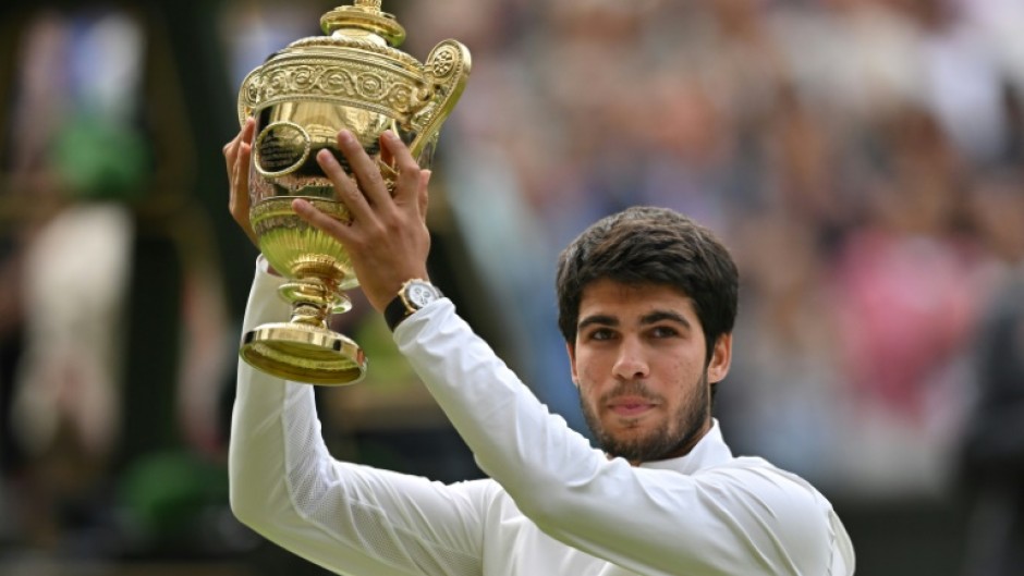 Champion: Carlos Alcaraz raises his trophy after beating Novak Djokovic 