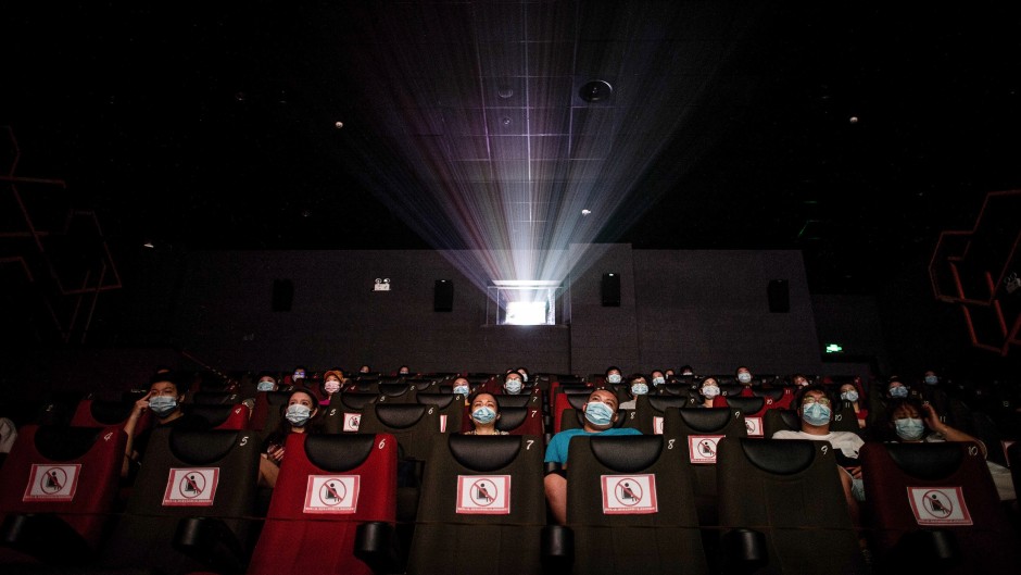 People watching a movie as they sit apart to ensure social distancing on the first day of the reopening of cinemas in China.
