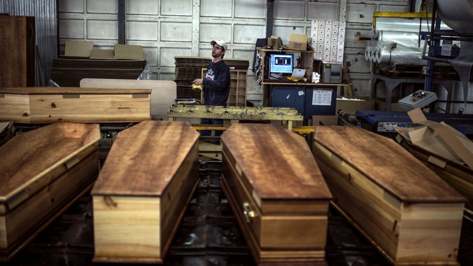 File: At a factory belonging to Europe's largest coffin maker, OGF, workers are doing overtime to meet demand from families parting with their loved ones.