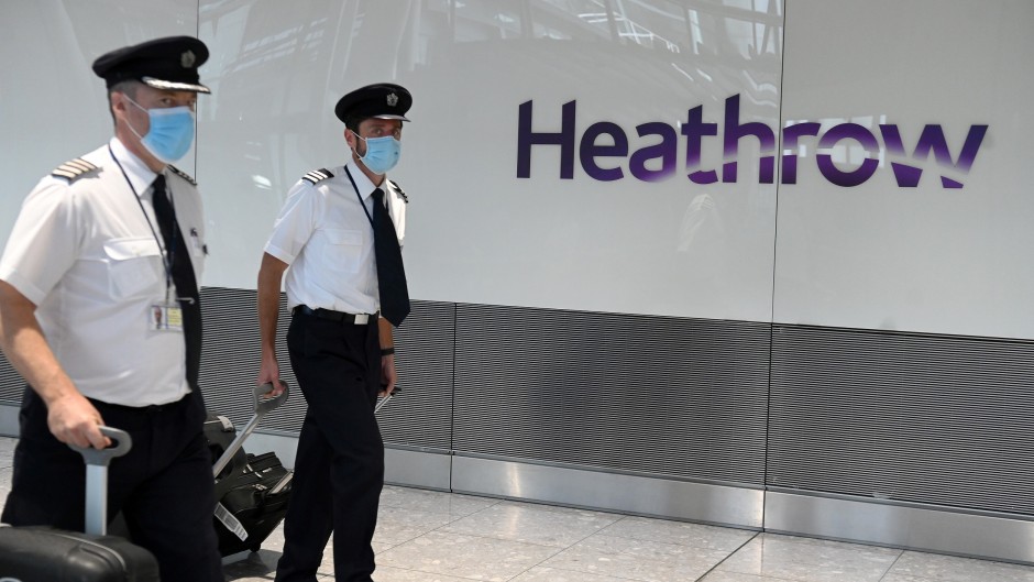 Air crew wearing face masks due to the COVID-19 pandemic arrive at Heathrow airport in London.
