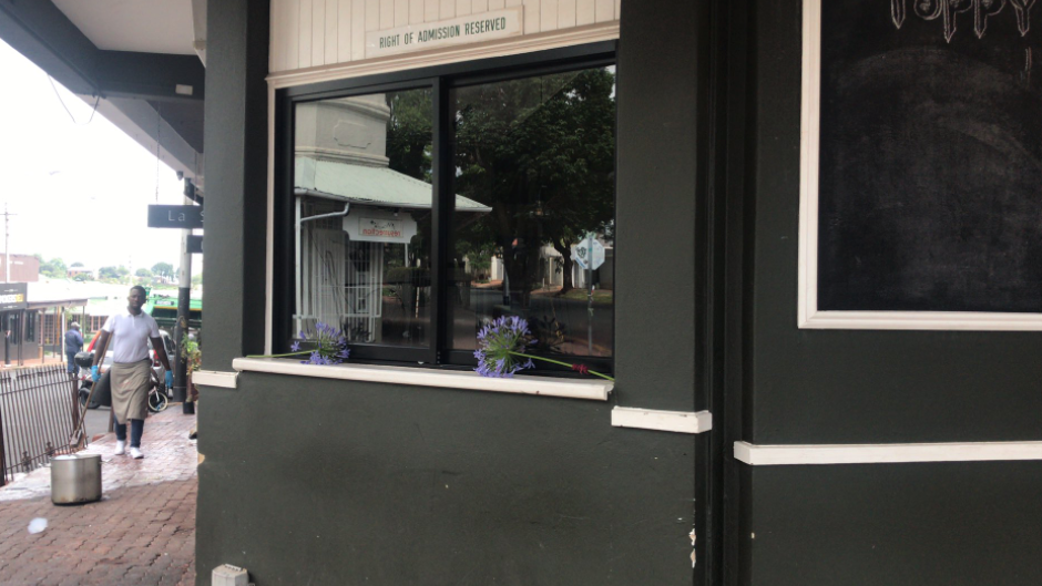 Flowers placed on a window sill at Poppy's restaurant in Melville following a deadly shooting.