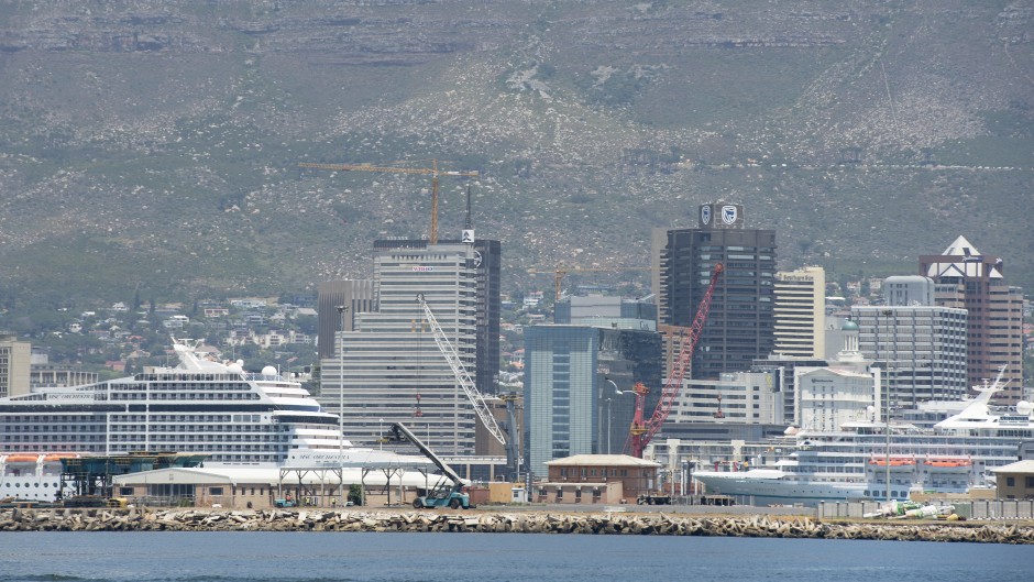 A view of cruise ships docked in the Cape Town Harbour, with the city and Table Mountain in the background .