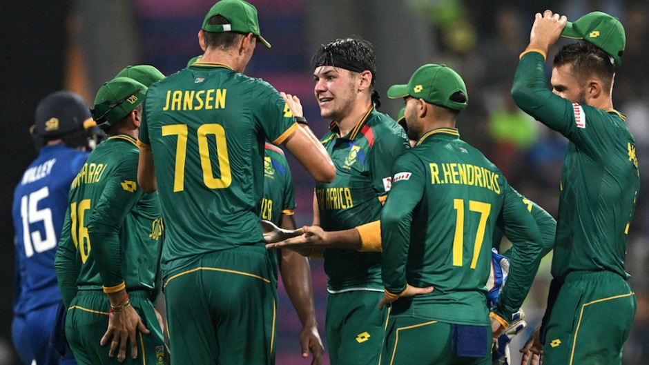 Gerald Coetzee (C) celebrates with teammates after taking the wicket of England's captain Jos Buttler during the 2023 ICC Men's Cricket World Cup ODI match. AFP/Punit Paranjpe
