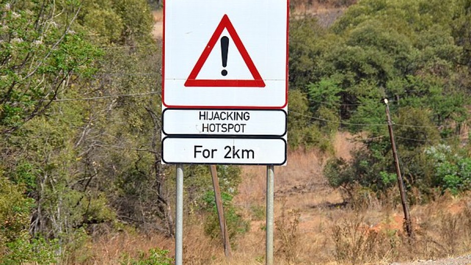 File: A sign warning motorists of a hijacking hotspot. Wikimedia Commons/Olga Ernst