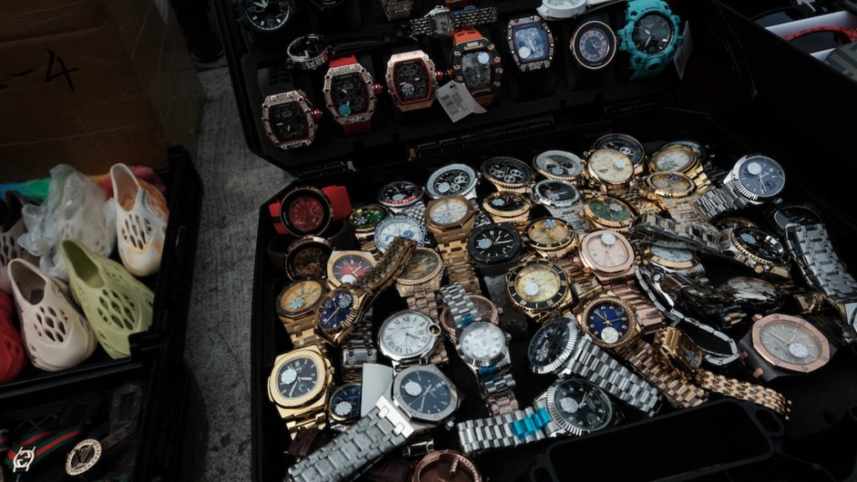 File: Knock-off luxury watches are displayed by sellers along a sidewalk. Spencer Platt/Getty Images/AFP 