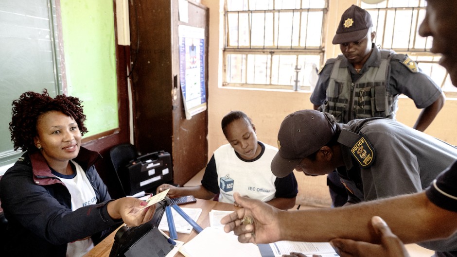 An IEC official gives back an identity document to a South African man after registering him as a voter. AFP/Luca Sola