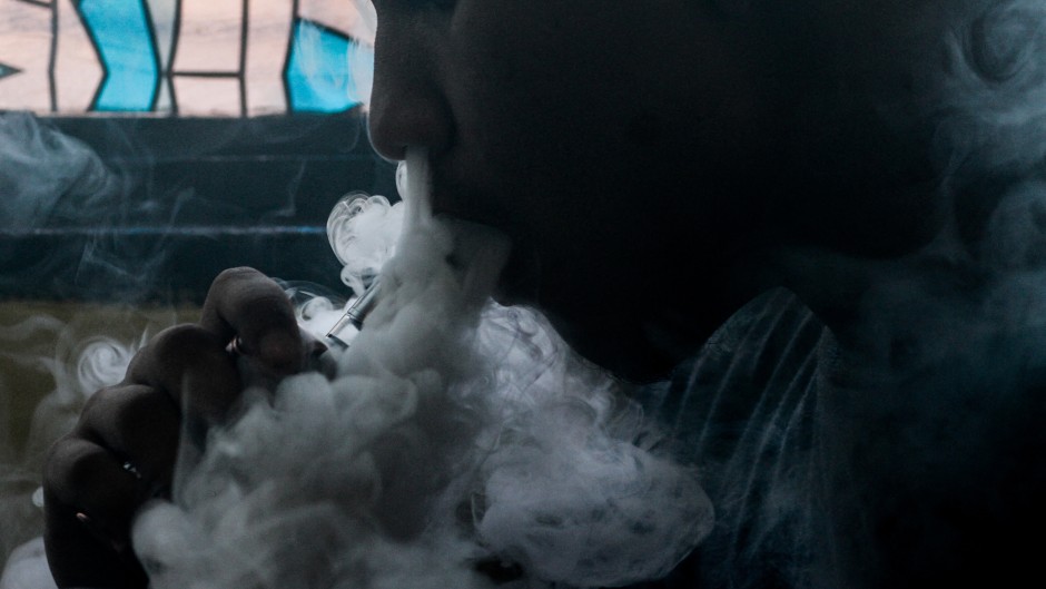 This photo illustration shows a customer smoking at a vape store.