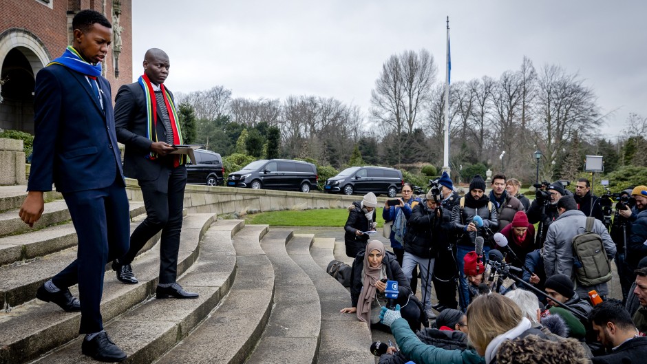 South Africa's Minister of Justice Ronald Lamola (R) exits the building to deliver remarks to journalists outside the International Court of Justice (ICJ) after the first day of hearings on the genocide case against Israel brought by South Africa, in The Hague on January 11, 2024.