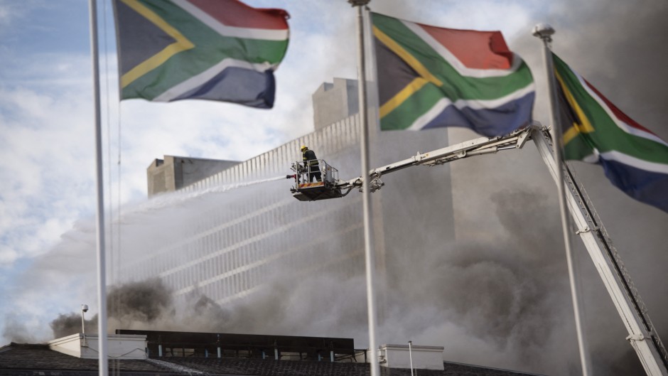 File: Firefighters extinguish a fire burning in the National Assembly, the main chamber of the South African Parliament buildings, on January 03, 2022, in Cape Town.