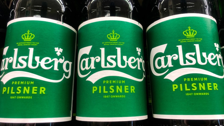 Carlsberg logos are seen on beer bottles. Jakub Porzycki/NurPhoto via AFP