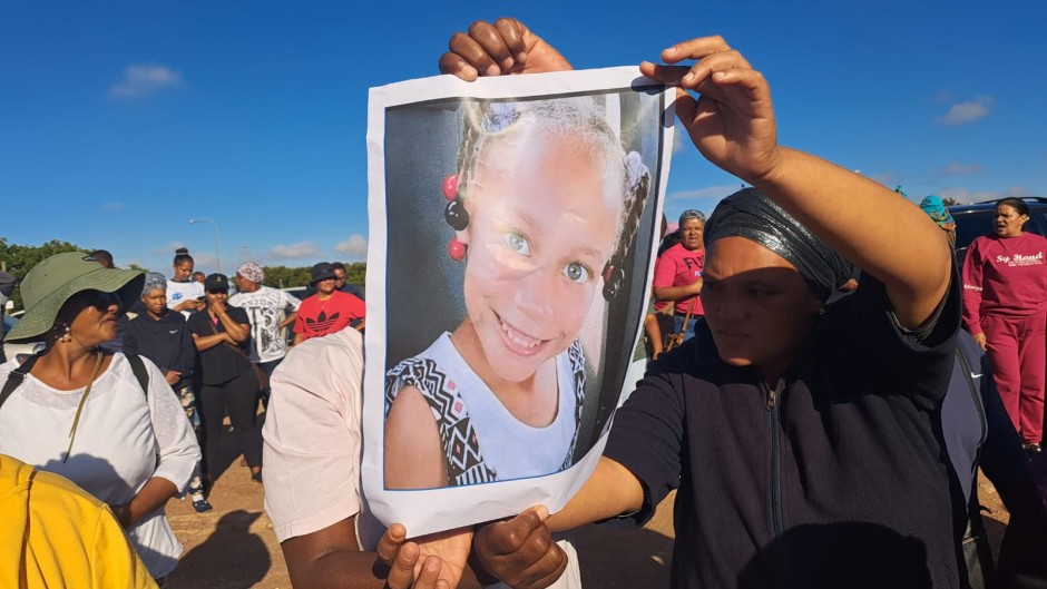 Community members holding a photo of Joshlin Smith. eNCA/Nobesuthu Hejana