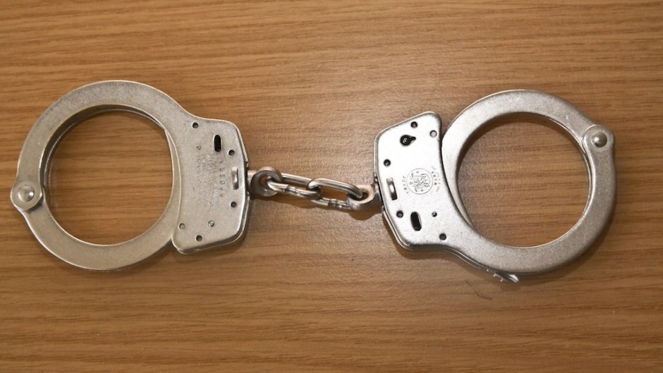 File: A pair of handcuffs on a table. Rolf Kremming/dpa Picture-Alliance via AFP