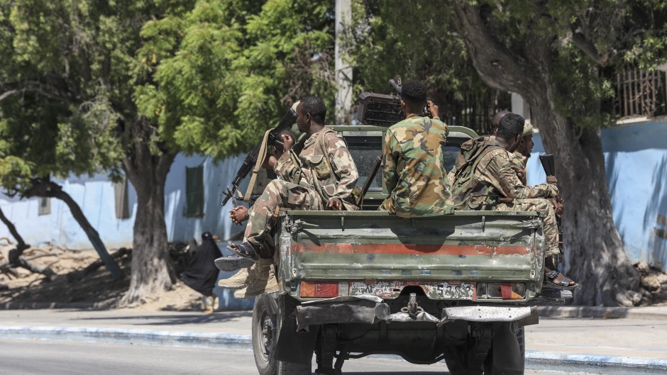 Somalian soldiers drive on the back of a military vehicle in a street near a hotel in Mogadishu. AFP/Hassan Ali ELMI