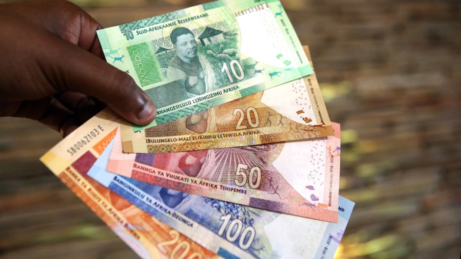 File: A man holds South African banknotes. AFP/Phill Magakoe 