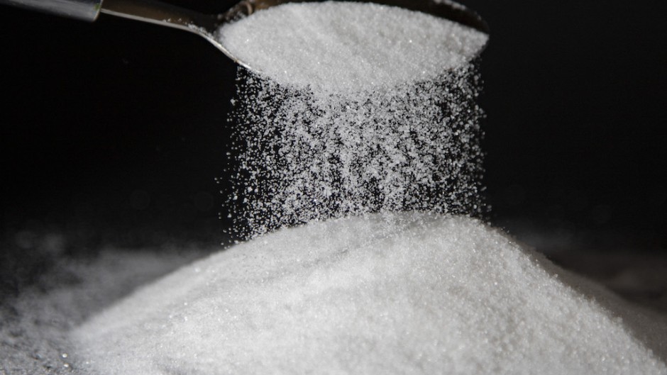 File: A person dumps sugar onto a table with a spoon. AFP/Thibaut Durand/Hans Lucas