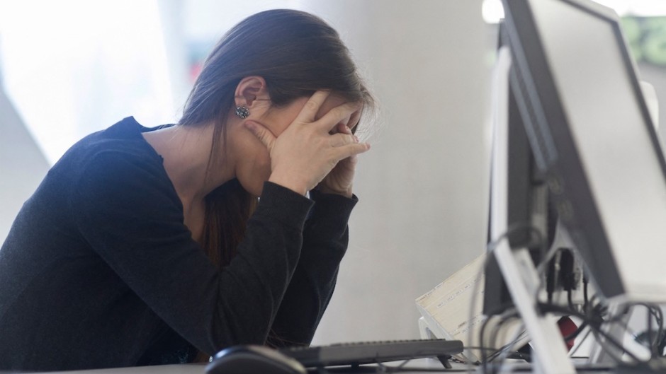 File: A woman sitting at a computer with her head in hands. Sigrid Gombert/Cultura Creative via AFP