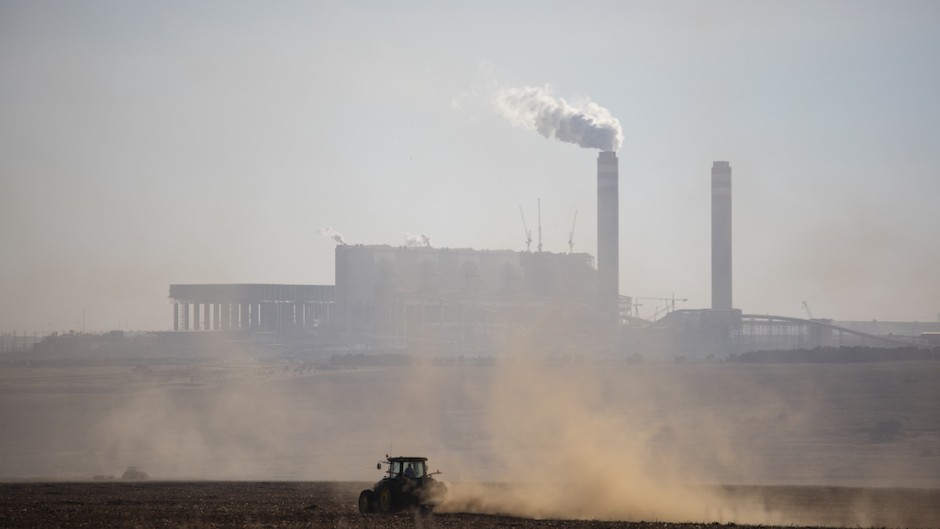 File: A farmer works with its tractor in front of the Kusile Power Station located in eMalahleni. AFP/Wikus de Wet