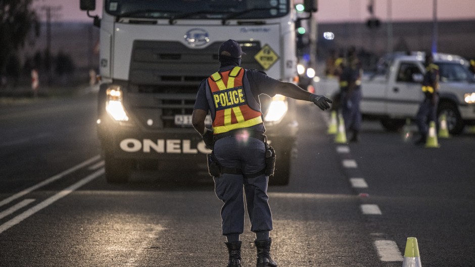 File: A South Africa Police Service's officer (SAPS) sets up a road block.
