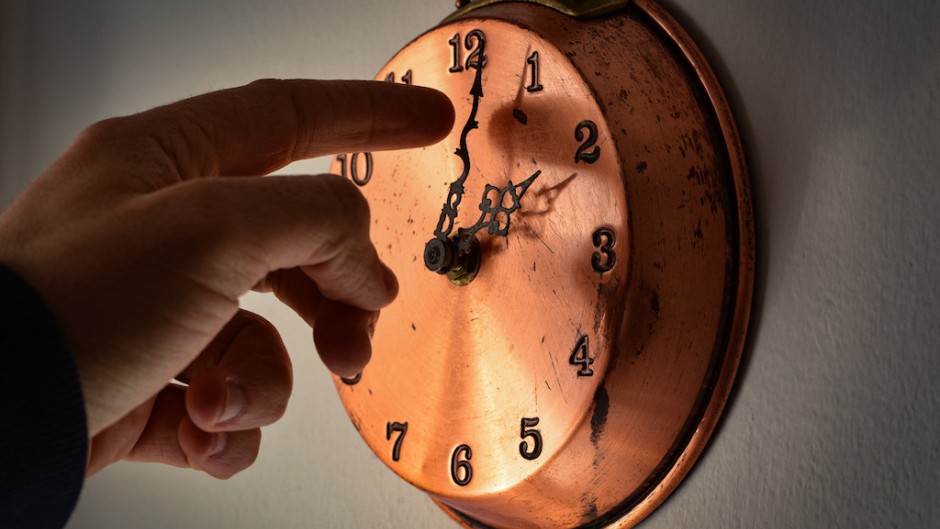 File: A man changing time on a clock. Lorenzo Di Cola/NurPhoto via AFP