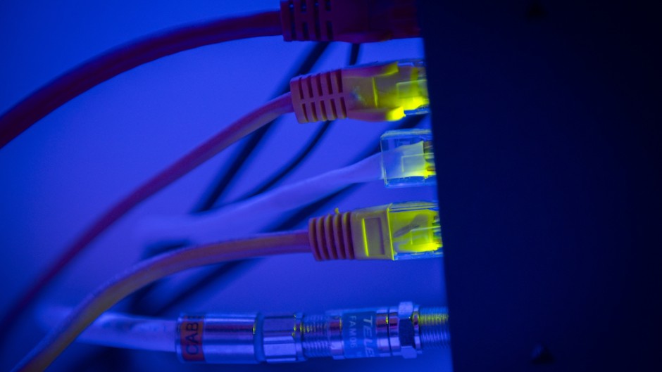 Ethernet cable wires lighting up connected to an internet router modem. Jaap Arriens/NurPhoto via AFP