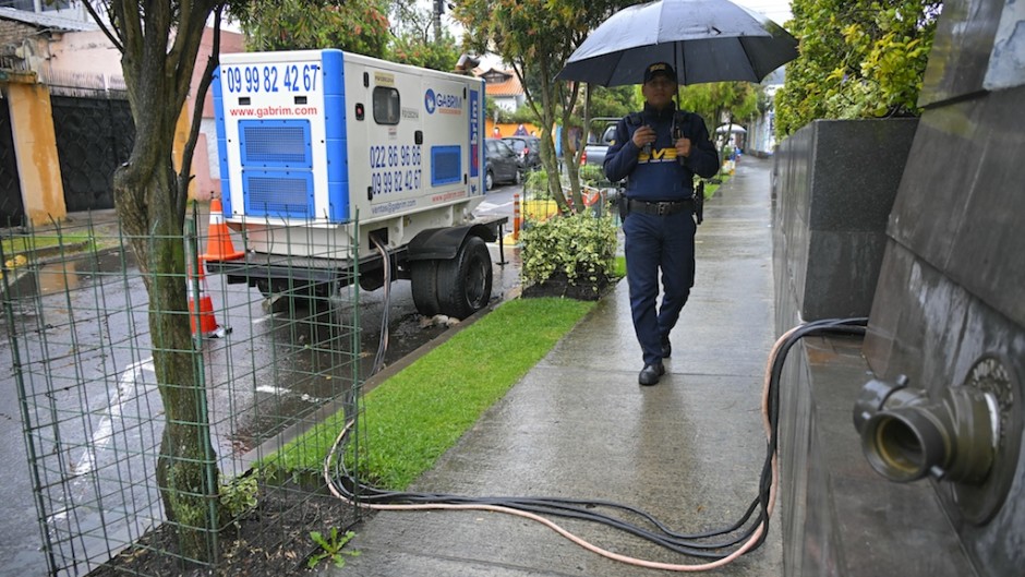 A securitu guard walks next to an electricity generator in Quito amid an electricity crisis sparked by a drought. AFP/Rodrigo Buendia