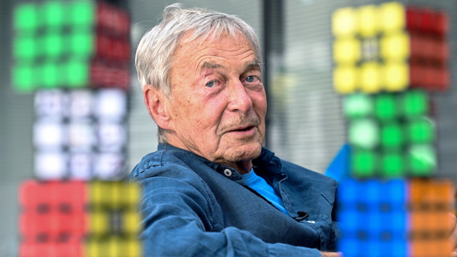 Hungarian inventor Erno Rubik sits next to several Rubik's Cubes. AFP/Attila Kisbenedek