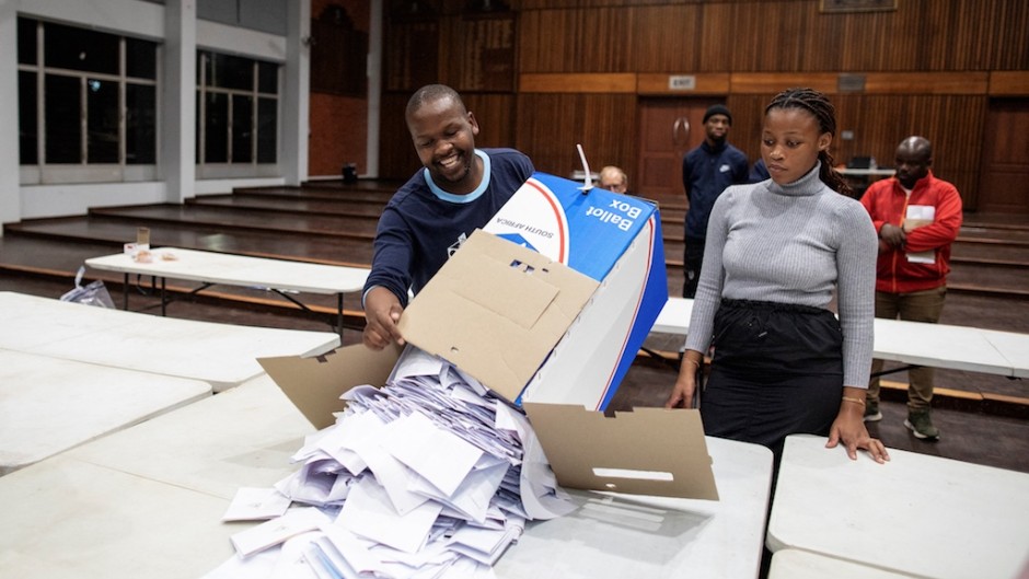 IEC) officials empty a ballot box during the vote counting process. AFP/Gianluigi Guercia