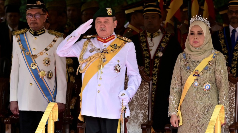 Malaysia's King Sultan Ibrahim Iskandar (C) saluting for the national anthem next to Queen Raja Zarith Sofiah. AFP/Malaysia's Department of Information