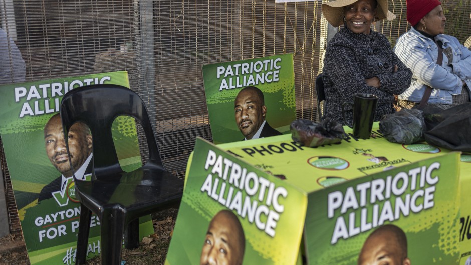 Patriotic Alliance (PA) supporters sit outside the Jan Hofmeyer Recreation Centre polling station in Brixton, Johannesburg on May 29, 2024, during South Africa’s general election.