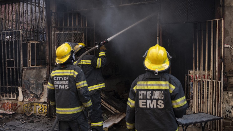 Firefighters extinguish a fire that broke out in a building in Johannesburg. AFP/Emmanuel Croset