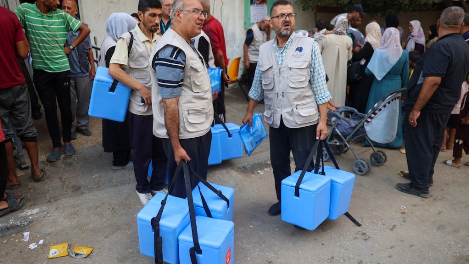 Health workers carry containers filled with Polio vaccines during a vaccination campaign in Zawayda. AFP/Eyad Baba.jpg