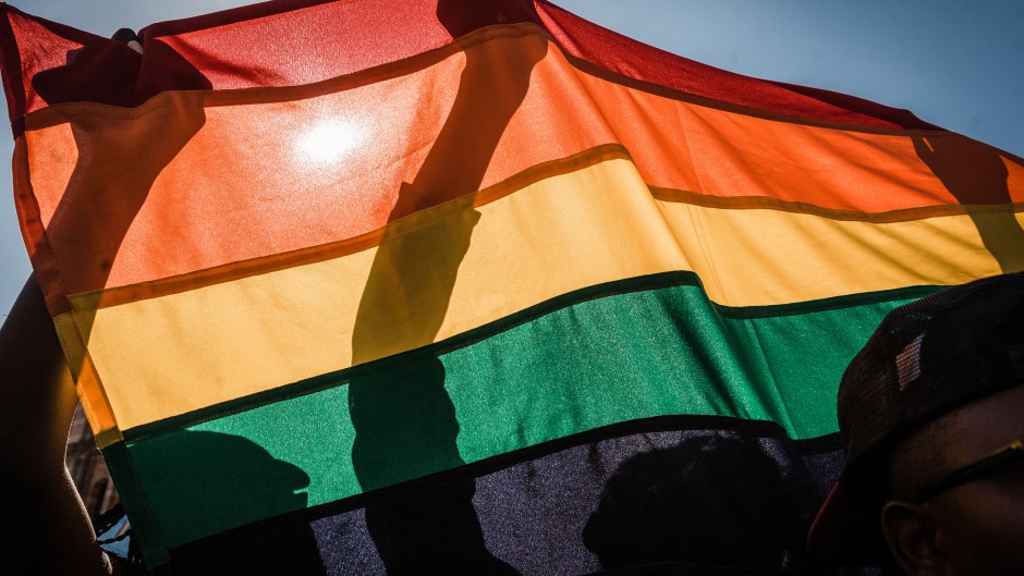 People with a rainbow flag take part in a Gay Pride Parade AFP/Rajesh Jantilal