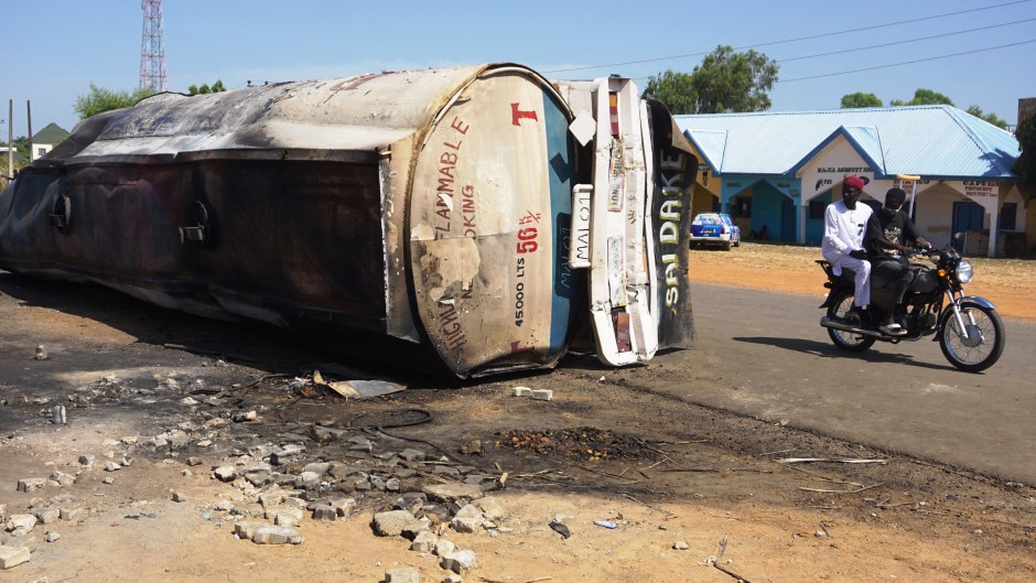A motorcycle rides past the remain of a fuel tanker whose explosion killed almost 150 people in Majiya. AFP/Aminu Abubakar