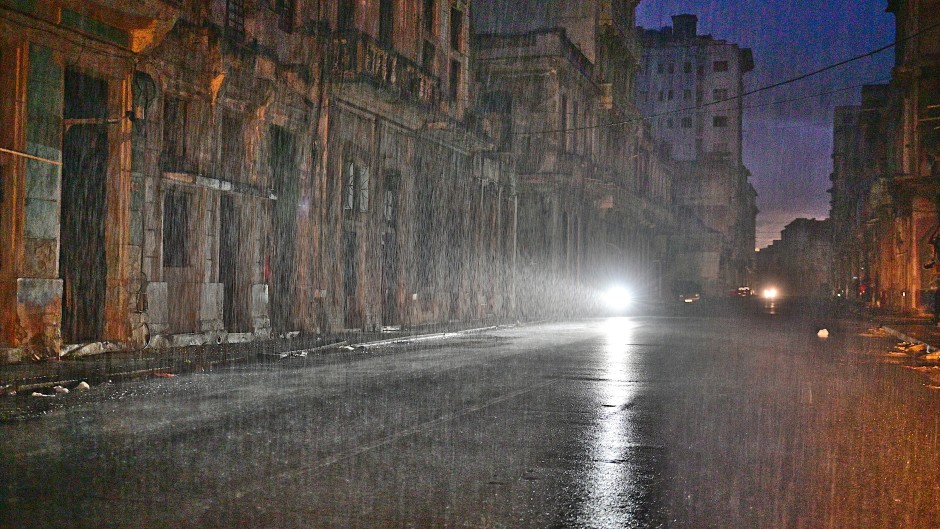 A motorcycle lights a street under pouring rain during a nationwide blackout caused by a grid failure in Havana, on October 19, 2024.