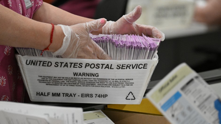 Election workers prepare mail-in ballots for tallying. AFP/Robyn Beck