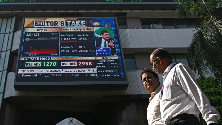 Pedestrians walk past a digital broadcast on the facade of Bombay Stock Exchange (BSE) in Mumbai. AFP/Indranil Mukherjee