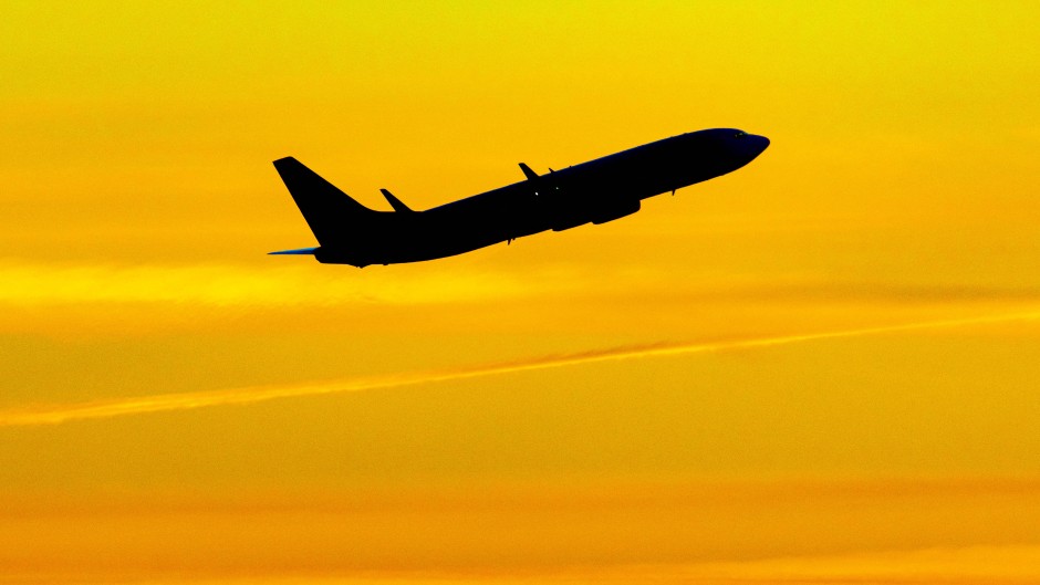Aircraft silhouette, a symbol illustration photo during the magic hour of a departing passenger plane. 