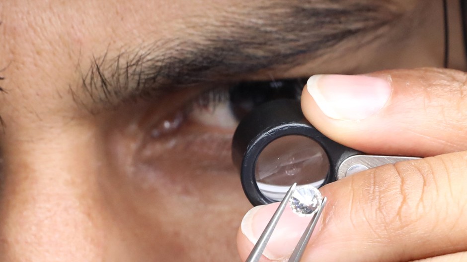 File: A supervisor checks the shape and color of a polished diamond. Rupak de Chowdhuri/NurPhoto via AFP