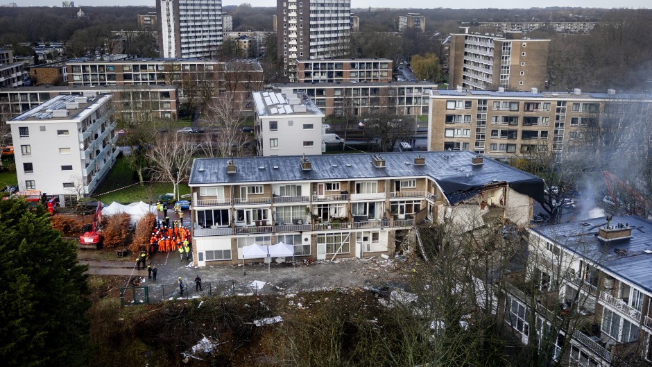 Emergency services stand at the site of a partially collapsed residential building following a fire and an explosion in The Hague on December 7, 2024. 