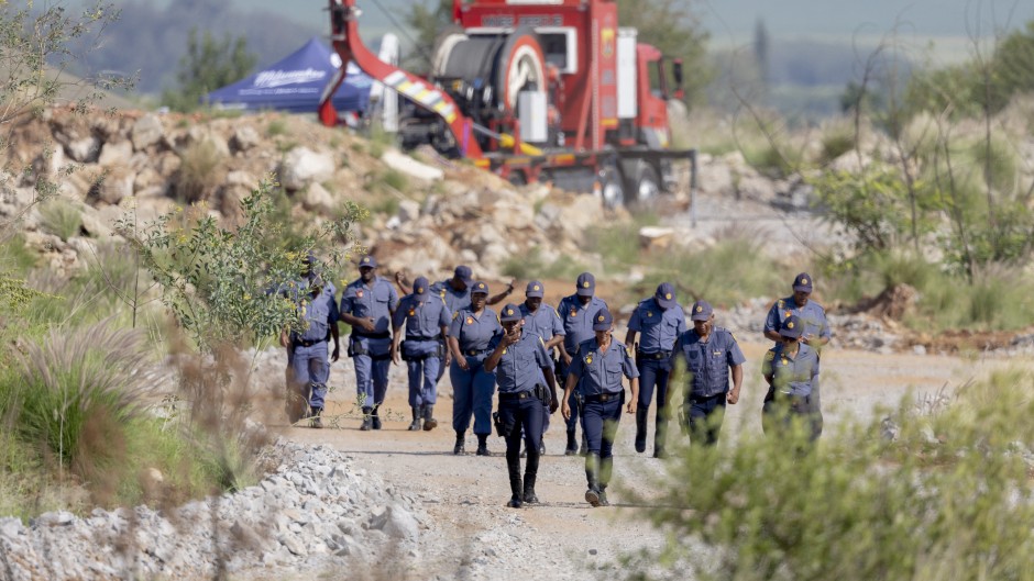 SAPS officers walk near a Metalliferous Mobile Rescue Winder during a rescue operation in Stilfontein. AFP/Christian Velcich