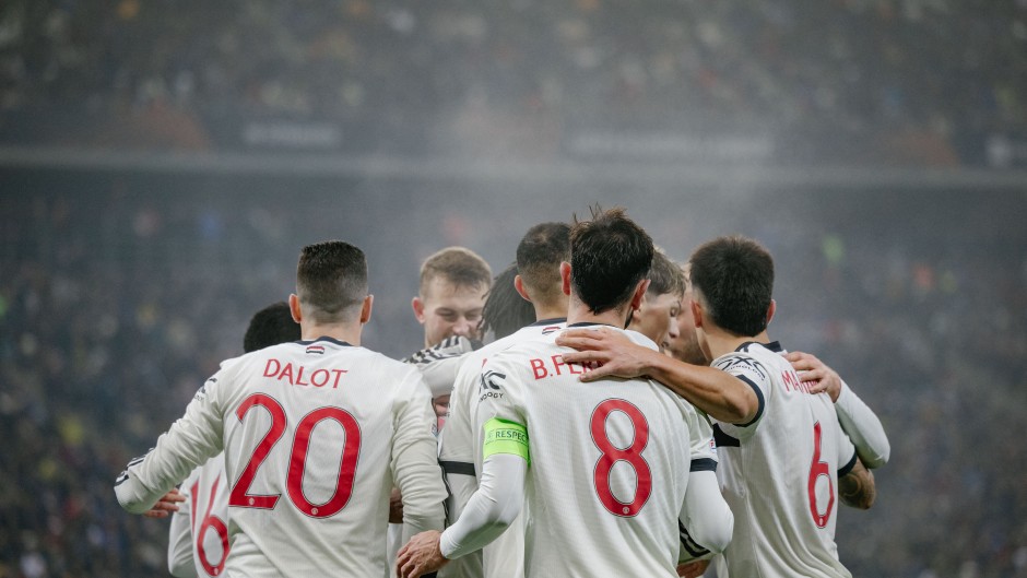 Manchester United's English midfielder #37 Kobbie Mainoo (hidden) celebrates with team mates after scoring the 0-2 goal. AFP/Andrei Pungovschi