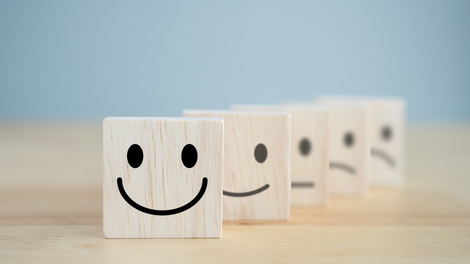 Wooden blocks representing happiness and sadness. GettyImages/Wipada Wipawin